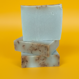 A stack of three rectangular bars of soap against a yellow background.