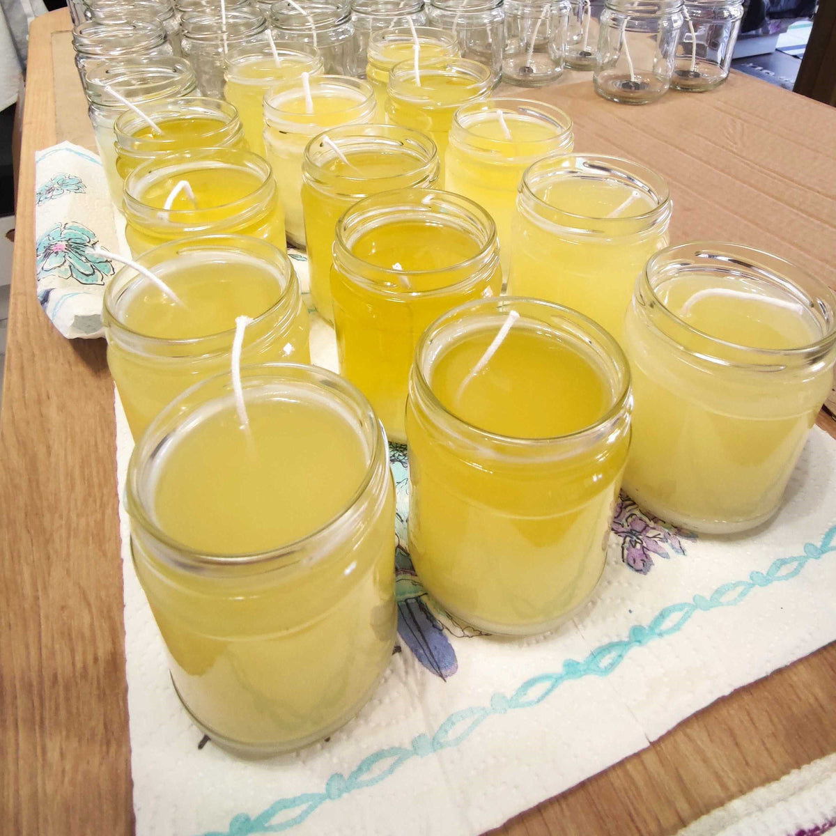 a table topped with lots of glasses filled with yellow liquid