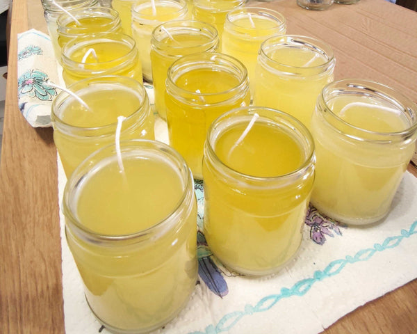 a table topped with lots of glasses filled with yellow liquid